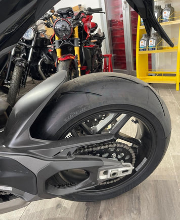 Dettaglio della ruota posteriore e forcellone in carbonio di una moto sportiva Ducati Panigale V4 presso VB GROUP